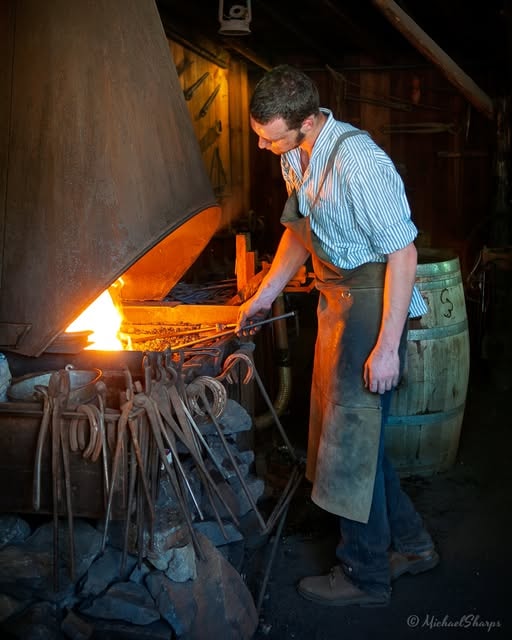 Blacksmith working at a glowing forge in Columbia State Historic Park